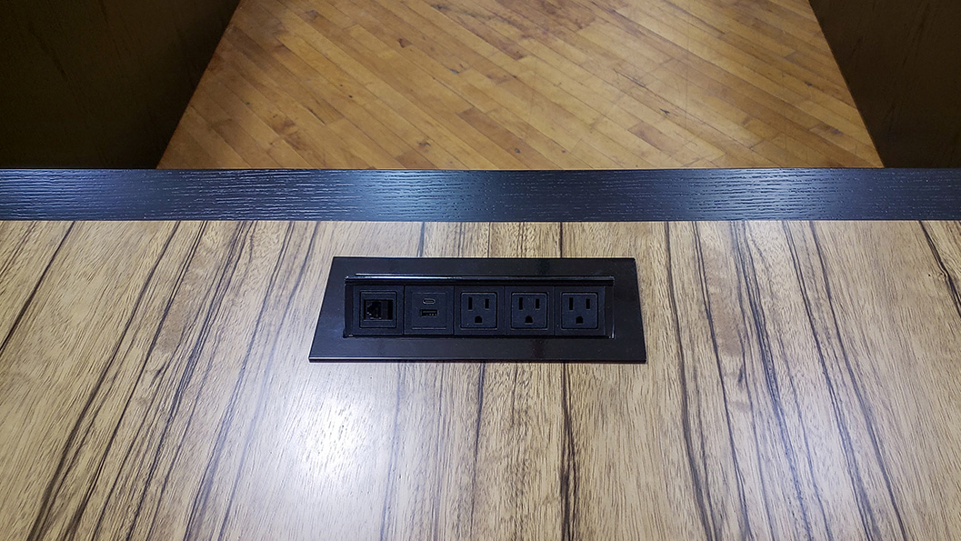 U shape conference table close up photo of AV integration, wood pairing and seamless veneer