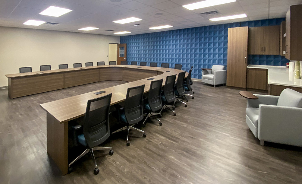 U shape conference table fully assembled onsite in client's room with AV integration facing TV media
