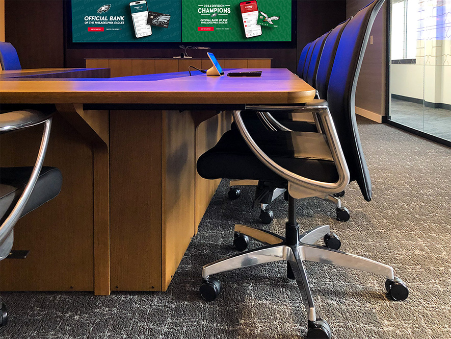 V shape conference table fully assembled onsite in client's room with AV integration facing TV media