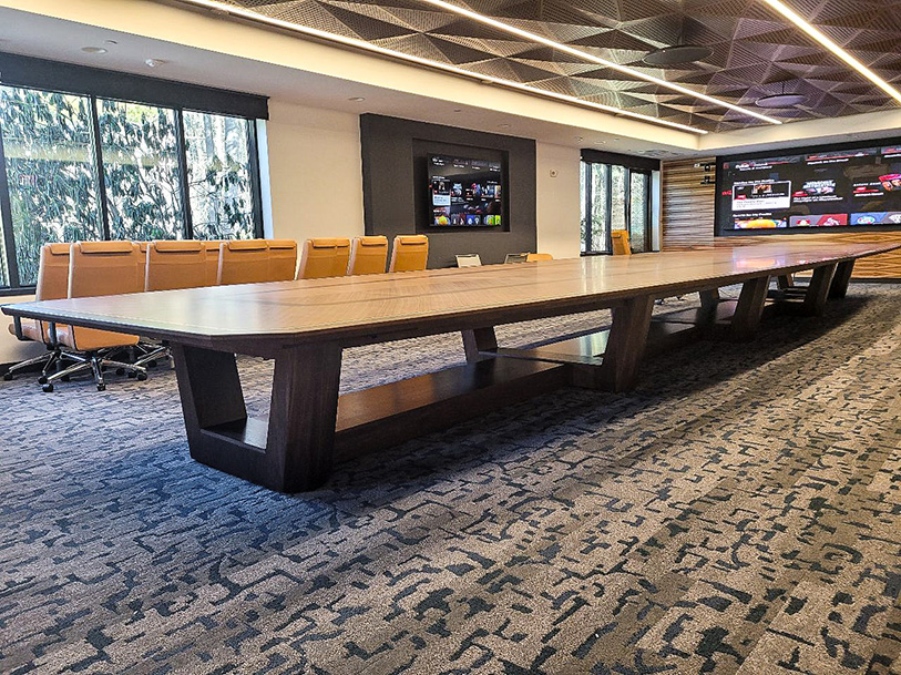 Intricate wood pattern boat conference table with sophisticated AV integration
